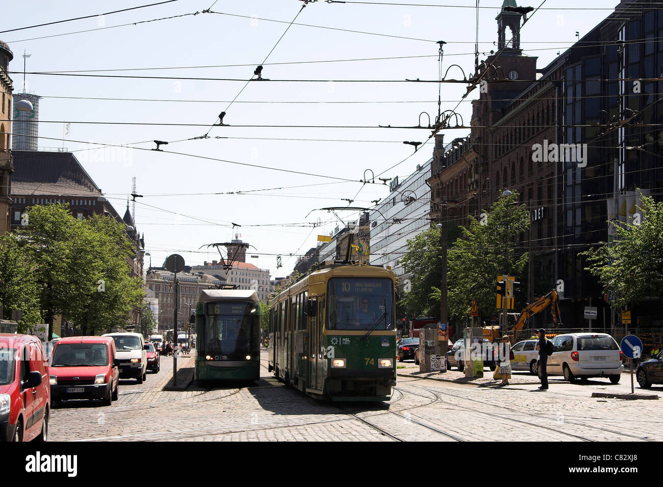 Strada trafficata scena con una fermata del tram e il traffico, Helsinki, Finlandia Foto Stock