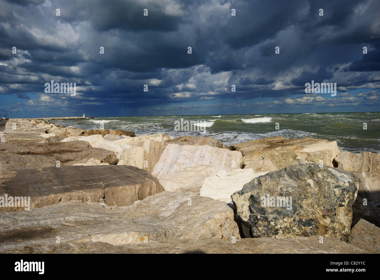 Onde che si infrangono sugli scogli durante una torbida e giornata di vento Foto Stock