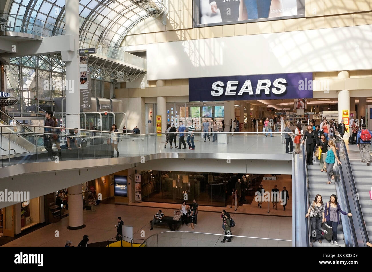 Persone su scale mobili nel Centro Commerciale per lo Shopping e Sears department store in ingresso, Toronto Eaton Centre Foto Stock