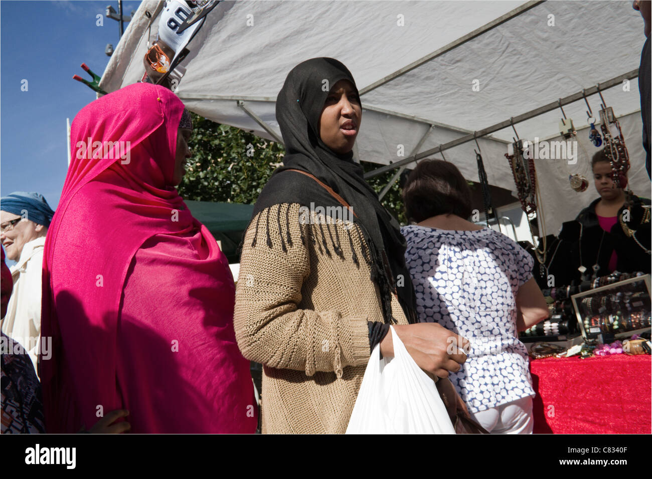 Due donne musulmane a piedi attraverso il mercato durante Eid Al-Fitr in Tensta Stockholm Svezia Foto Stock
