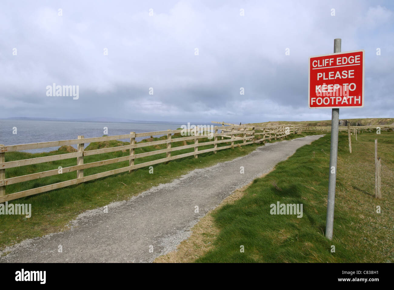 Un segnale di avvertimento di pericolo sul ciglio della scogliera a piedi a Ballybunion Foto Stock