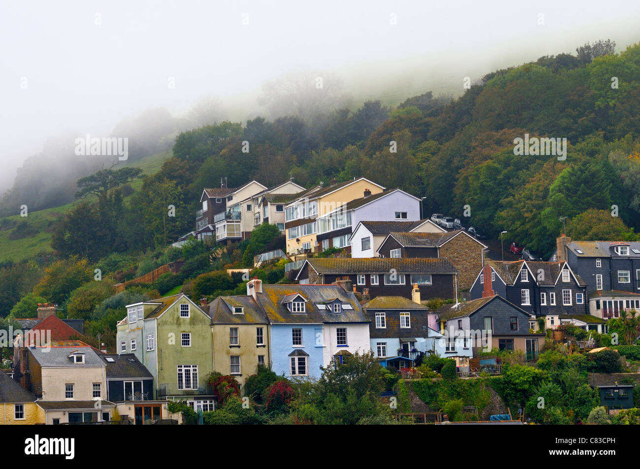Nebbia in rotolamento sulle colline verso un grappolo di case Foto Stock