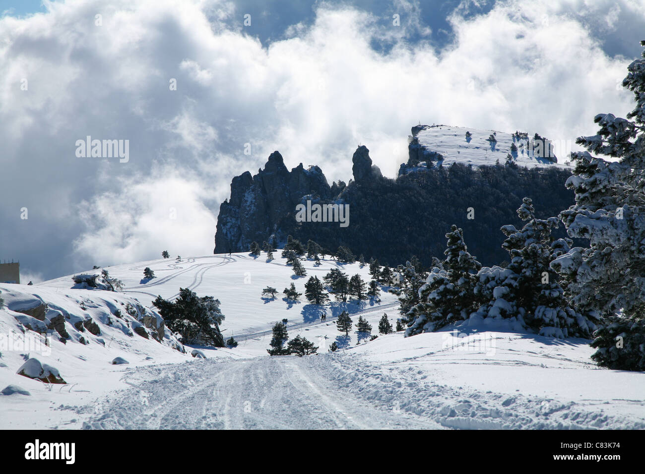 Paesaggio invernale. La strada verso le montagne all orizzonte sopra le nuvole. Foto Stock