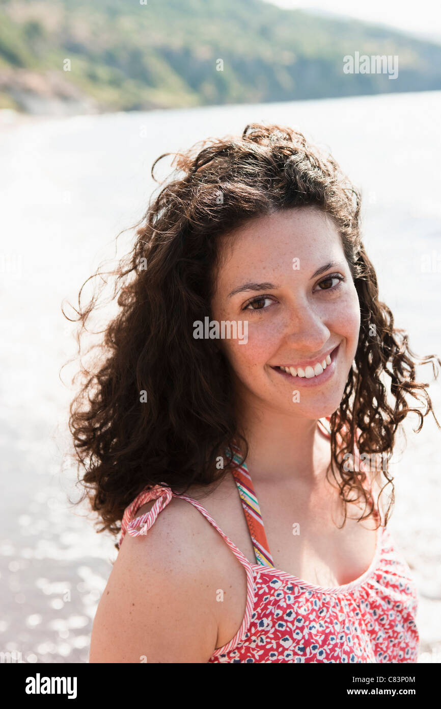 Donna sorridente dal lago Foto Stock