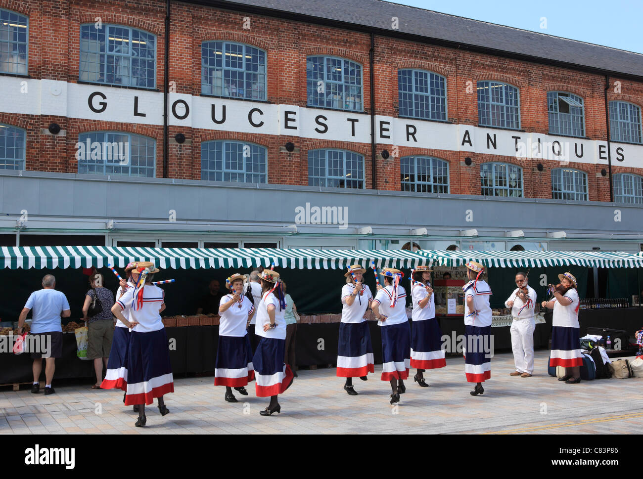 Un gruppo di ballerini di morris nella parte anteriore del mercato al centro theAntiques da Gloucester Quays, Gloucestershire, England, Regno Unito Foto Stock