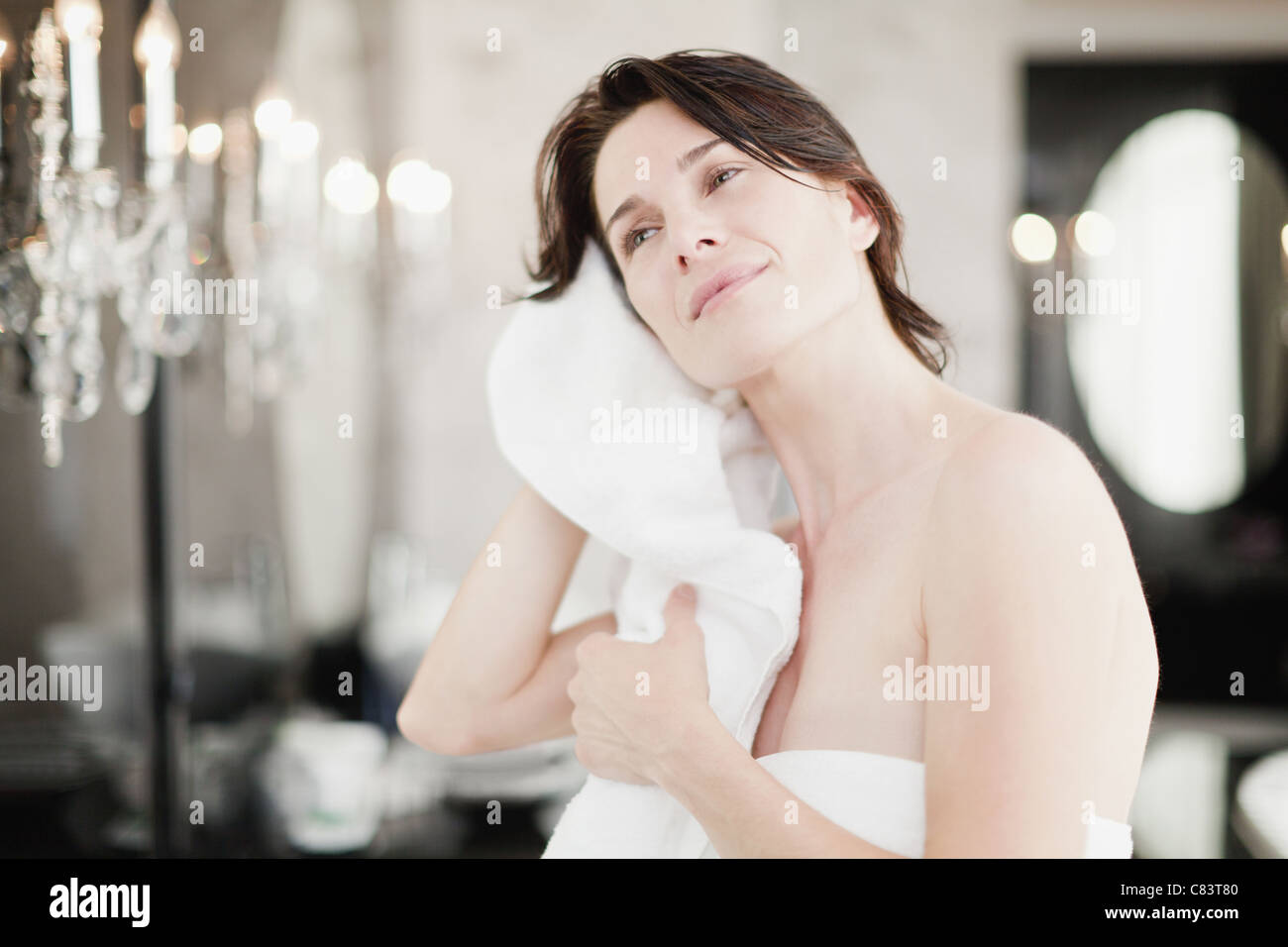 Donna asciugando i capelli in camera da letto Foto Stock