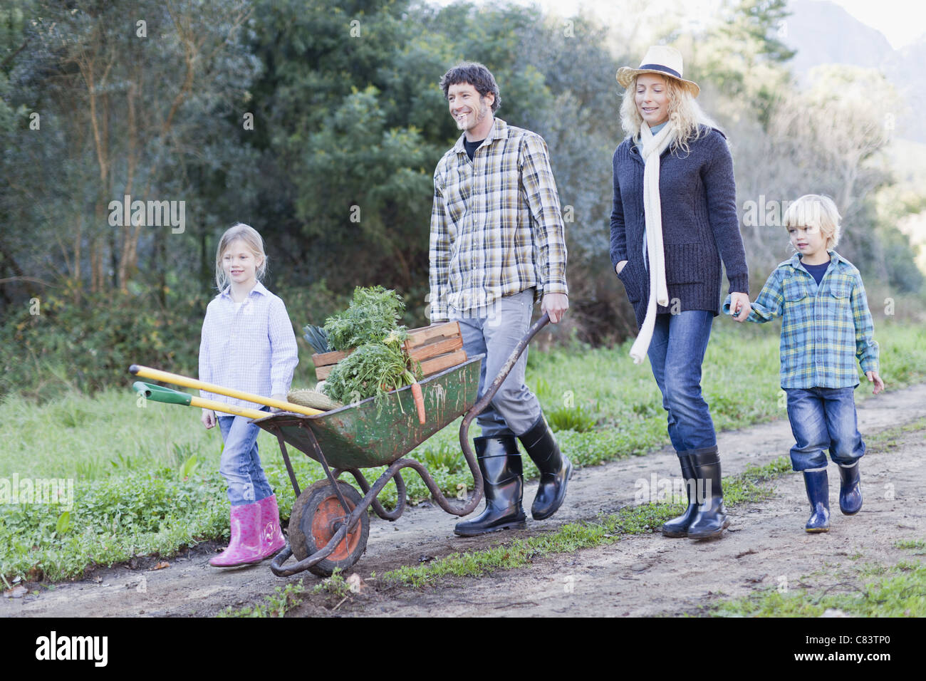 Famiglia con carriola sul percorso di sporcizia Foto Stock