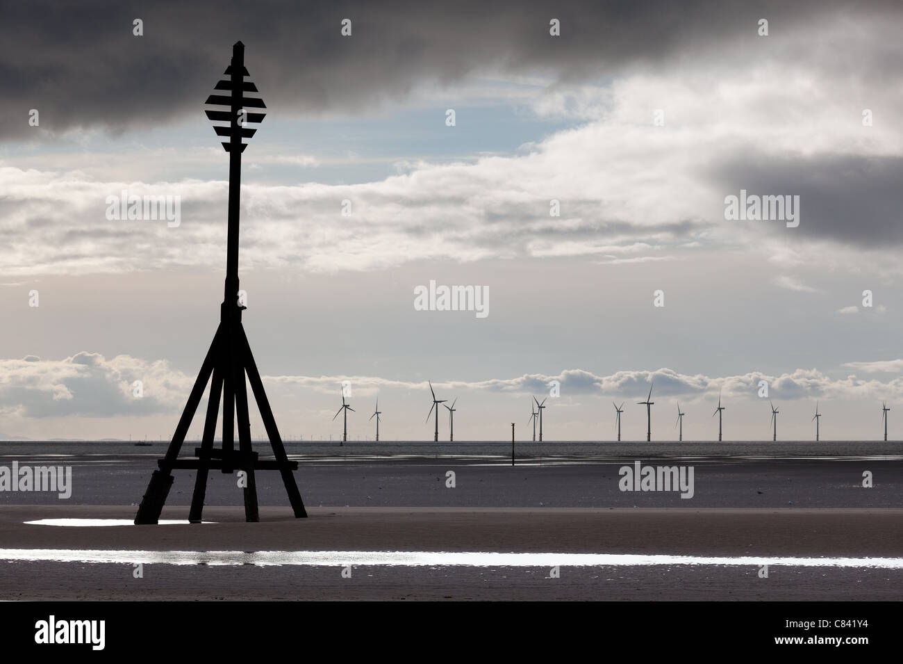 Le turbine eoliche in oceano fuori da una spiaggia di sabbia vicino al Liverpool in un freddo e nuvoloso giorno Foto Stock