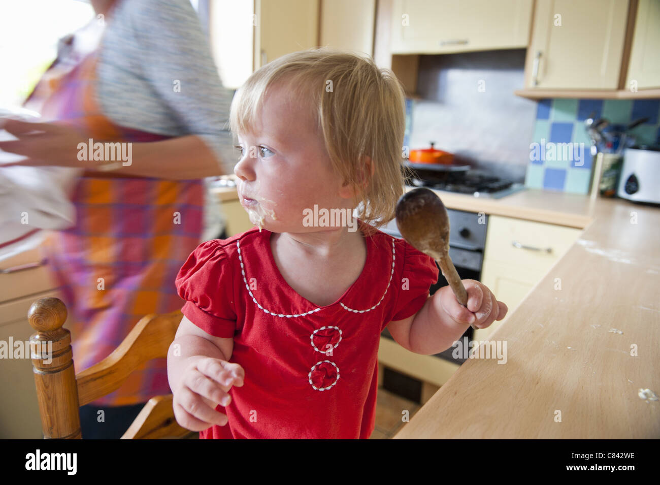 Il Toddler girl la cottura con la madre Foto Stock