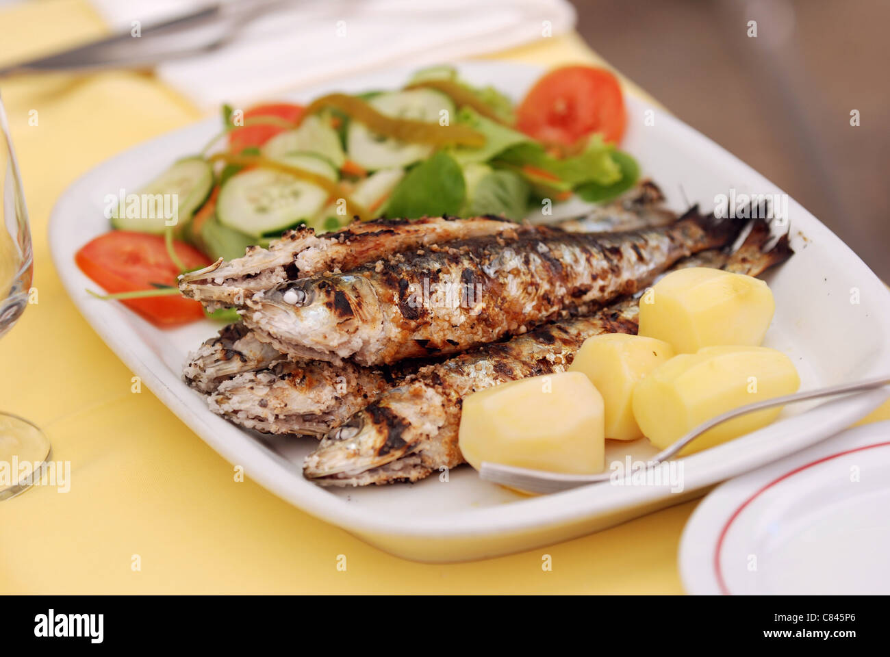 Sardine grigliate con patate e insalata mista Foto Stock