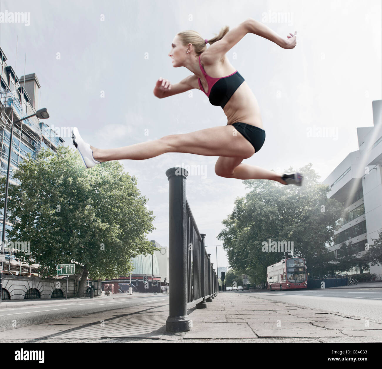 Atleta saltando bannister su strada Foto Stock