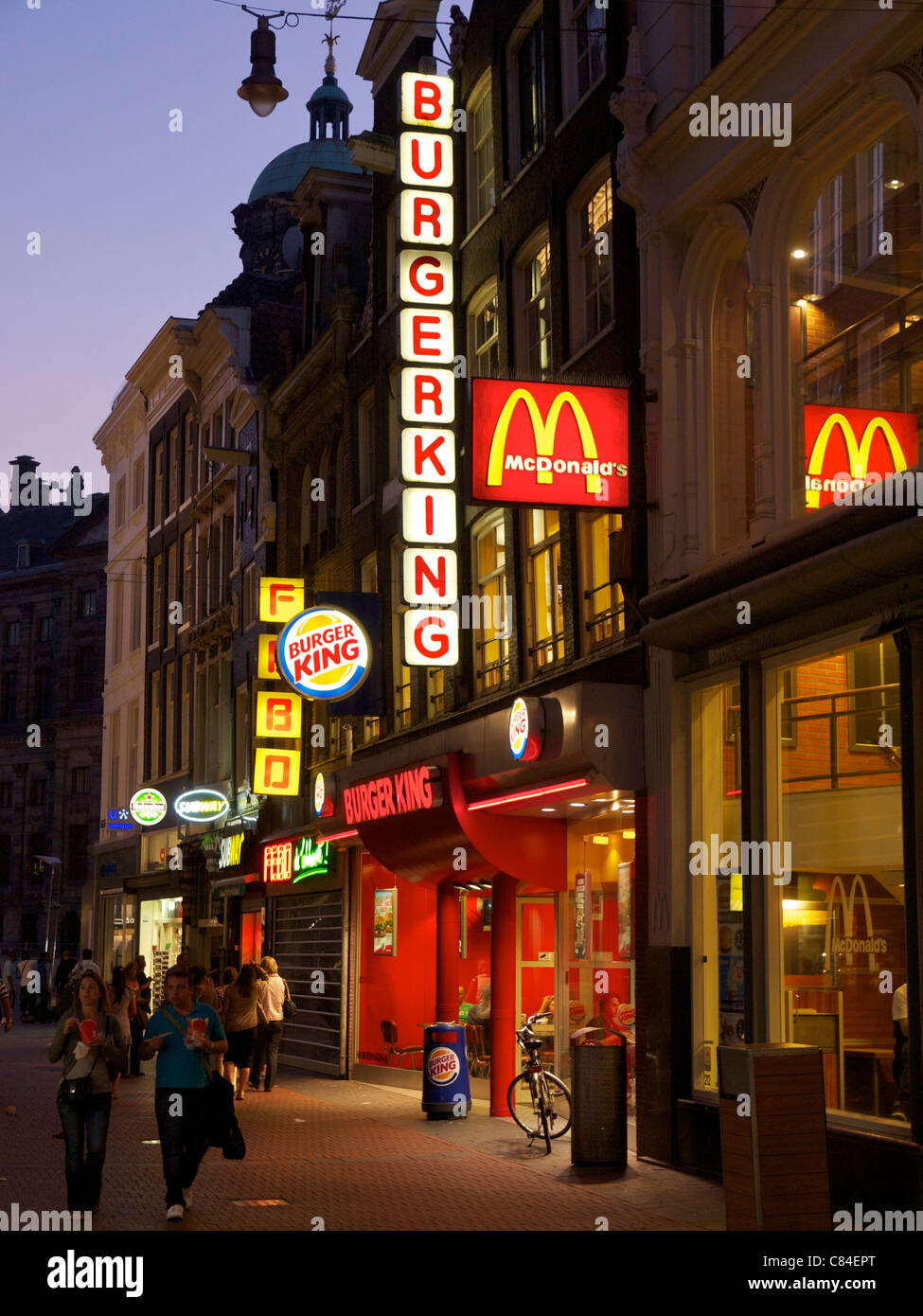 Il fast food segni di notte sul Nieuwendijk nel centro della città di Amsterdam, Paesi Bassi. Foto Stock