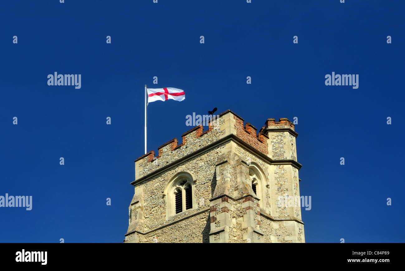 Una tipica chiesa inglese torre, con St George's Cross battenti bandiera Foto Stock