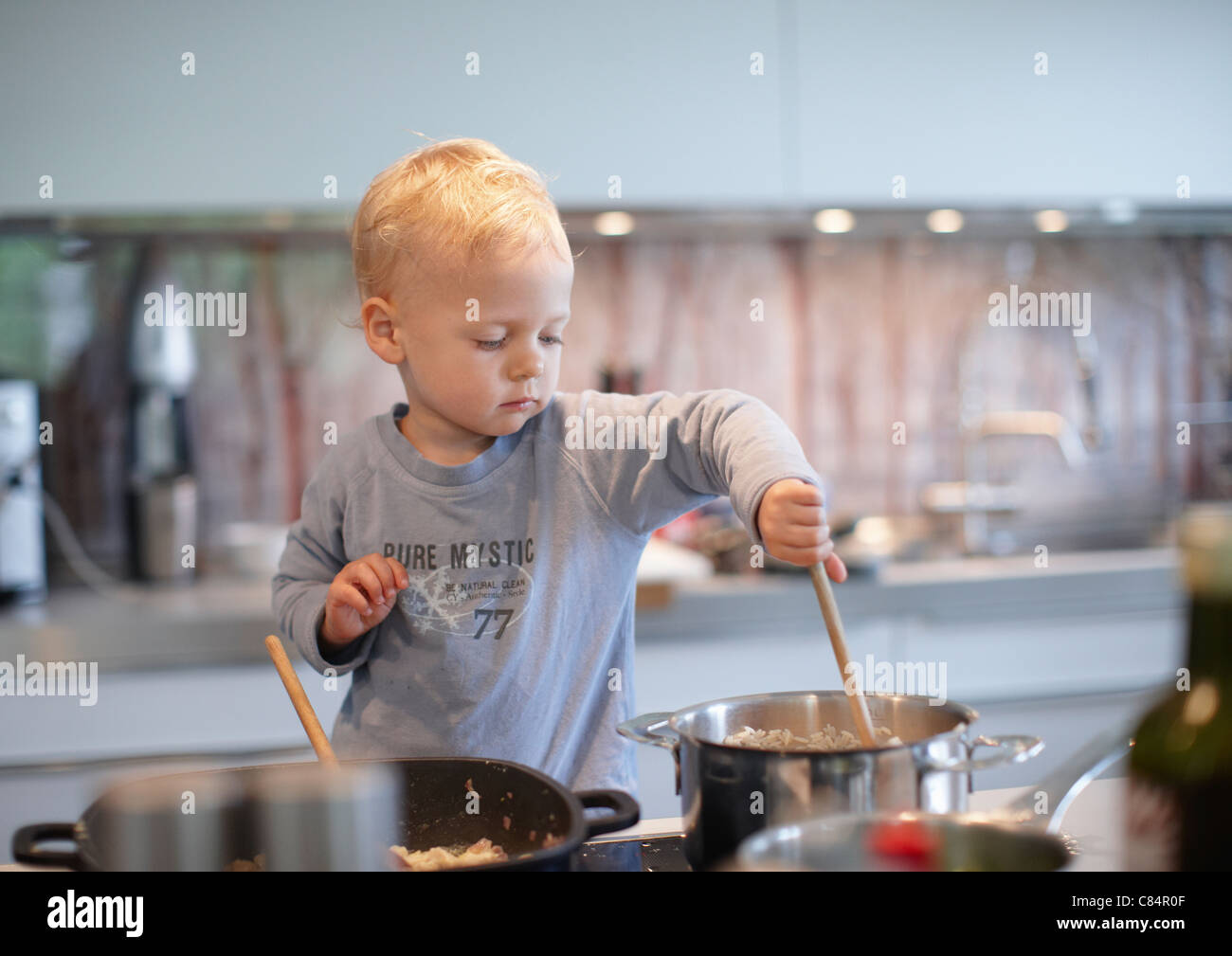 Il Toddler boy cottura in cucina Foto Stock