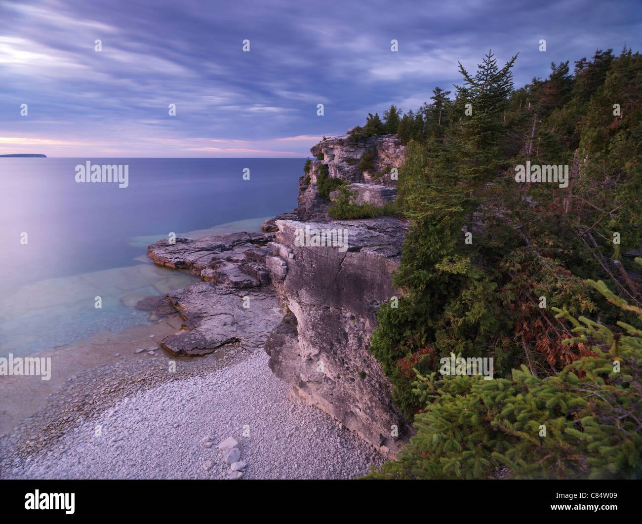 Tramonto stupendo scenario del Georgian Bay spiaggia rocciosa e scogliere coperte con alberi di cedro. Bruce Peninsula National Park, Ontario Foto Stock