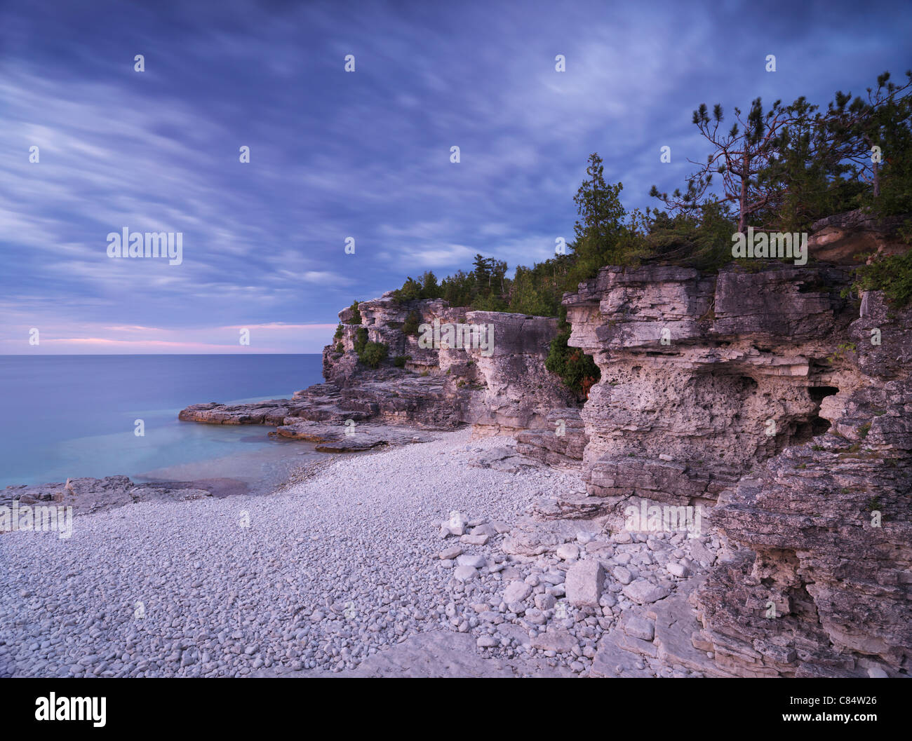 Tramonto stupendo scenario del Georgian Bay spiaggia rocciosa e scogliere abitate da alberi di cedro. Bruce Peninsula National Park, Ontario Foto Stock