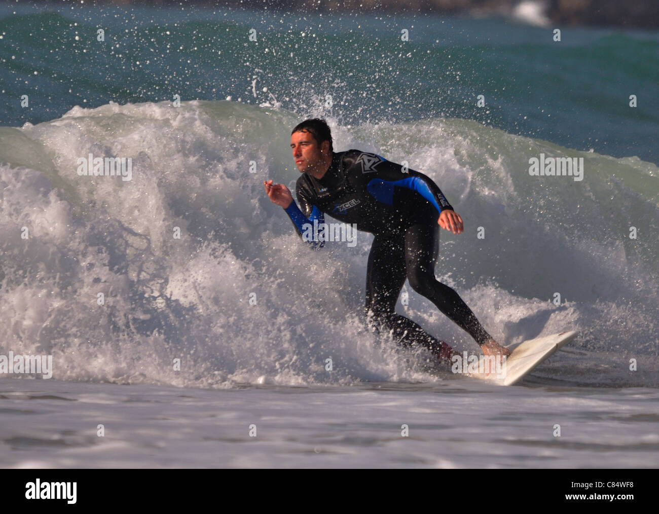 Un singolo surfista maschio cavalcare un onda Foto Stock