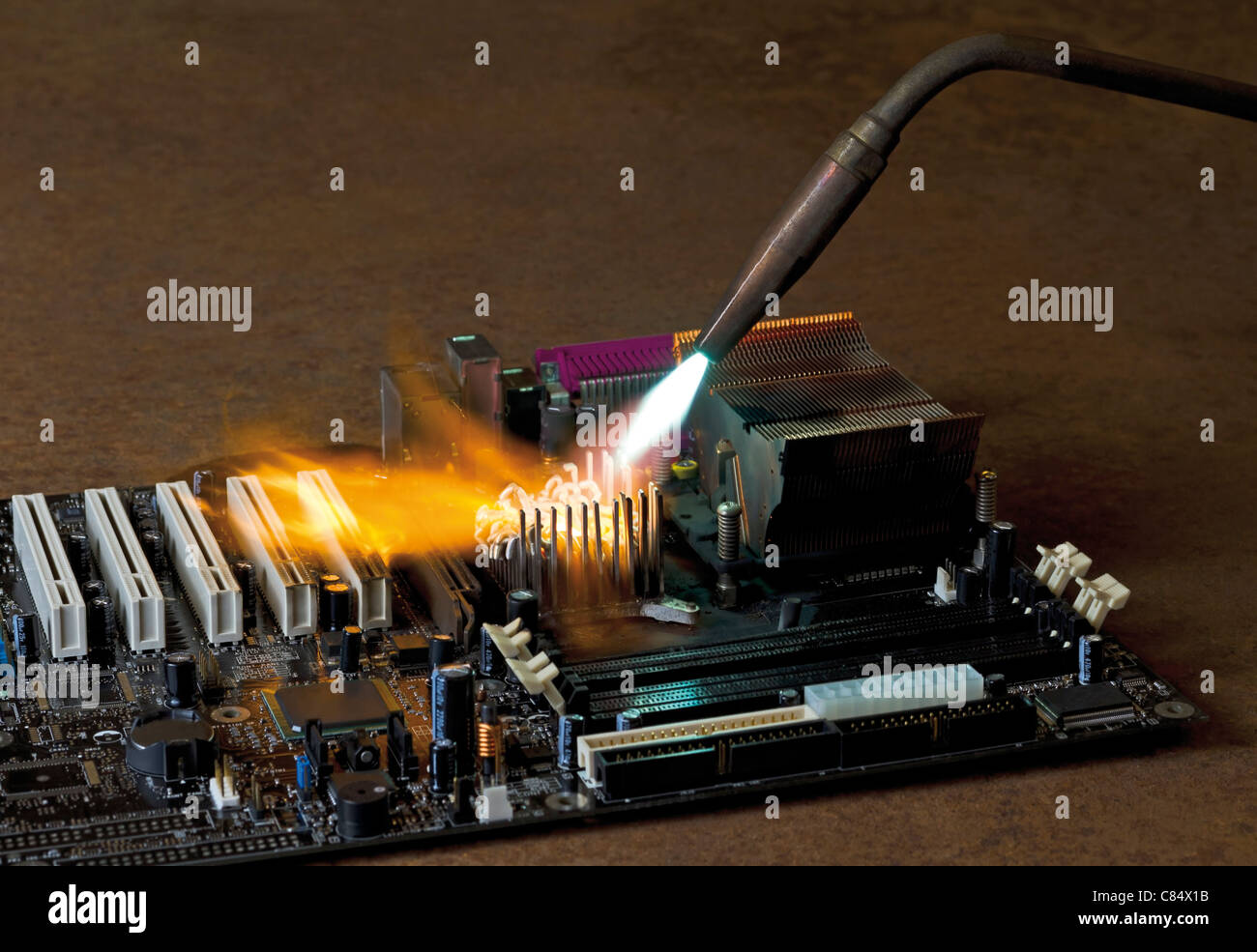 Sbatti fiamme da una saldatura rorch durante la masterizzazione di una scheda principale che si trova in atmosfera arrugginito Foto Stock