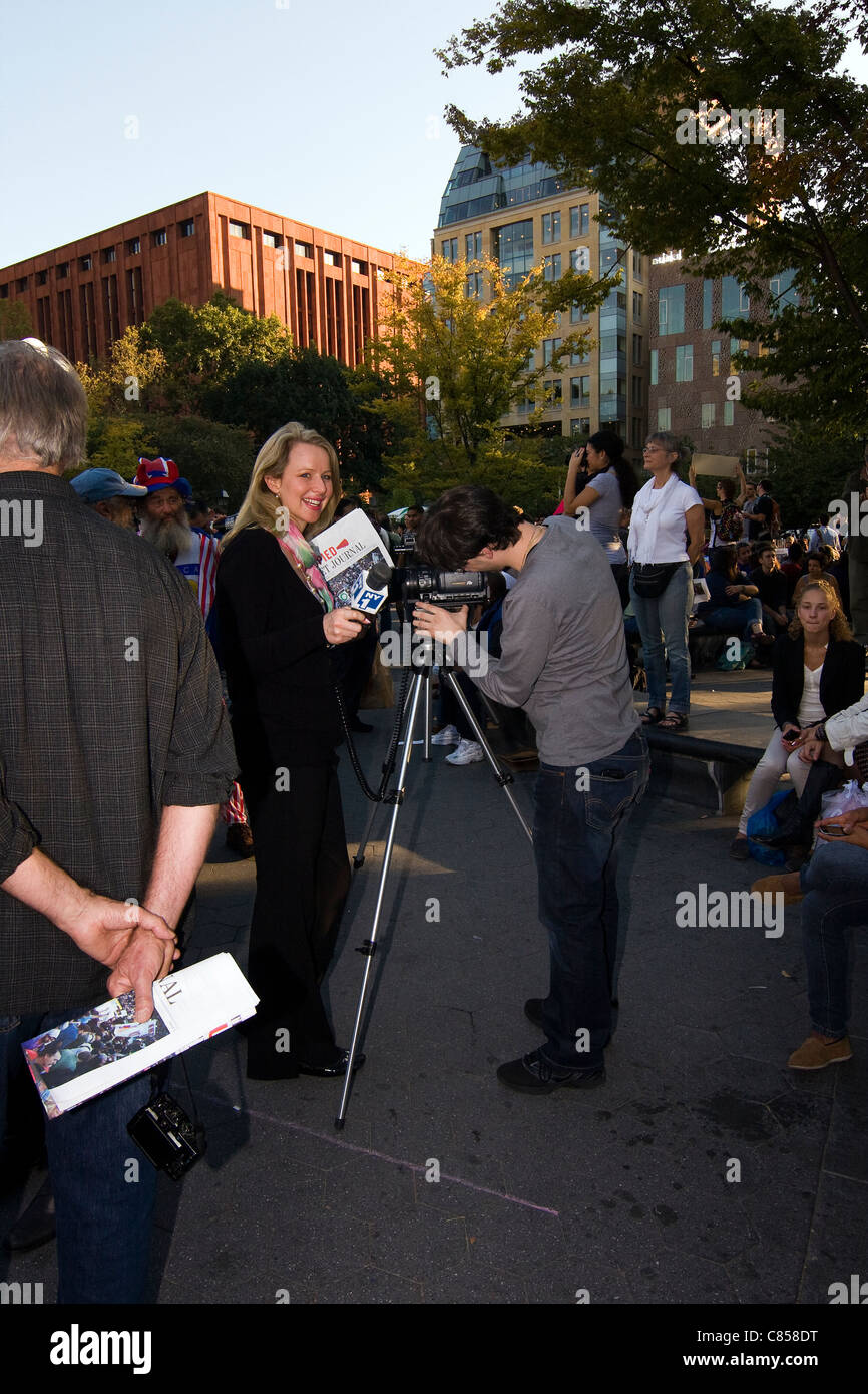 NY1 Reporter Erica Ferrari gesticolando con un microfono mentre reporting sulla occupare Wall Street proteste a Washington Sq. Park Foto Stock