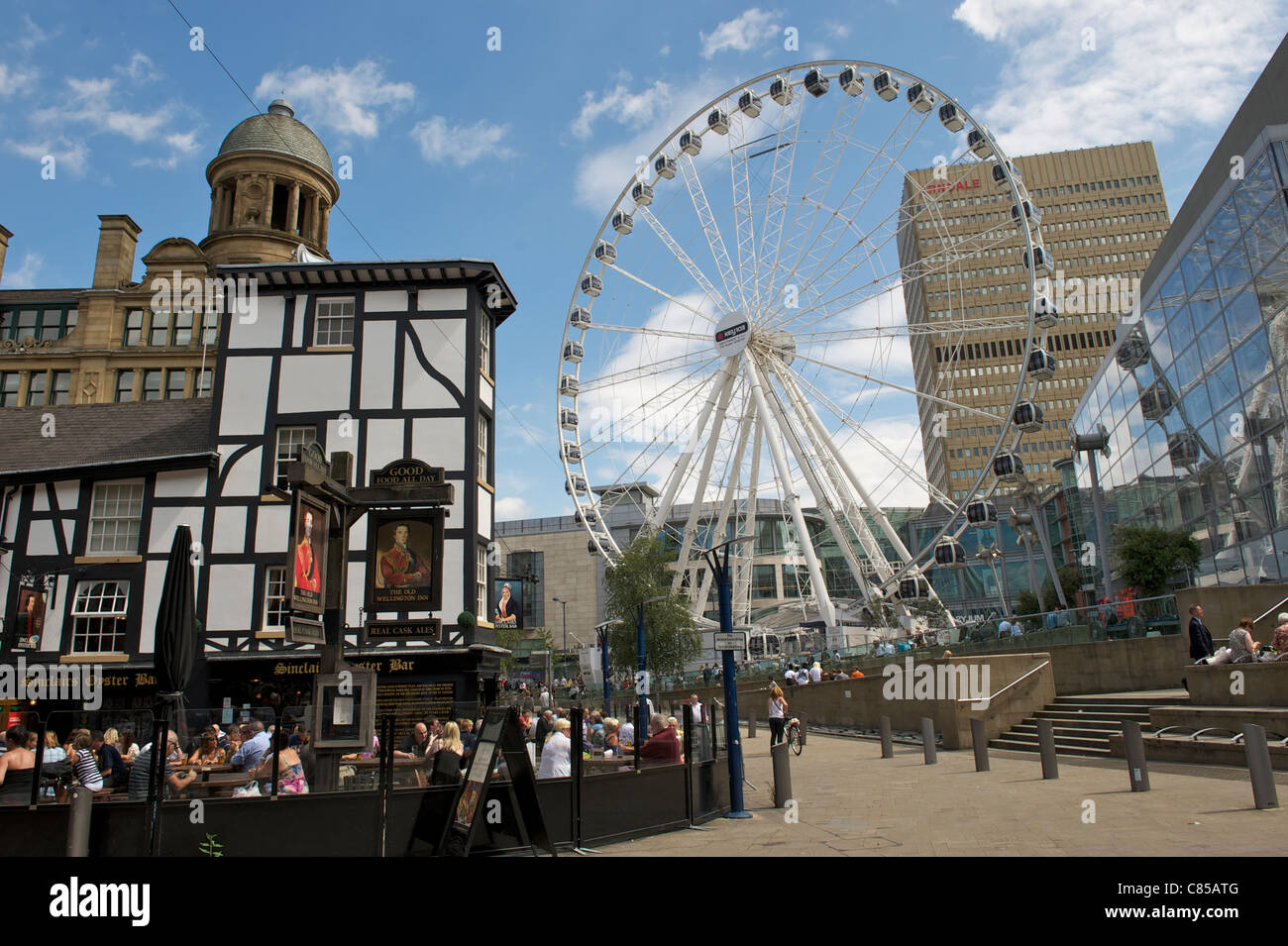 Il centro della città di Manchester, Exchange Square - Grande Ruota a fianco del vecchio pub di Wellington Foto Stock