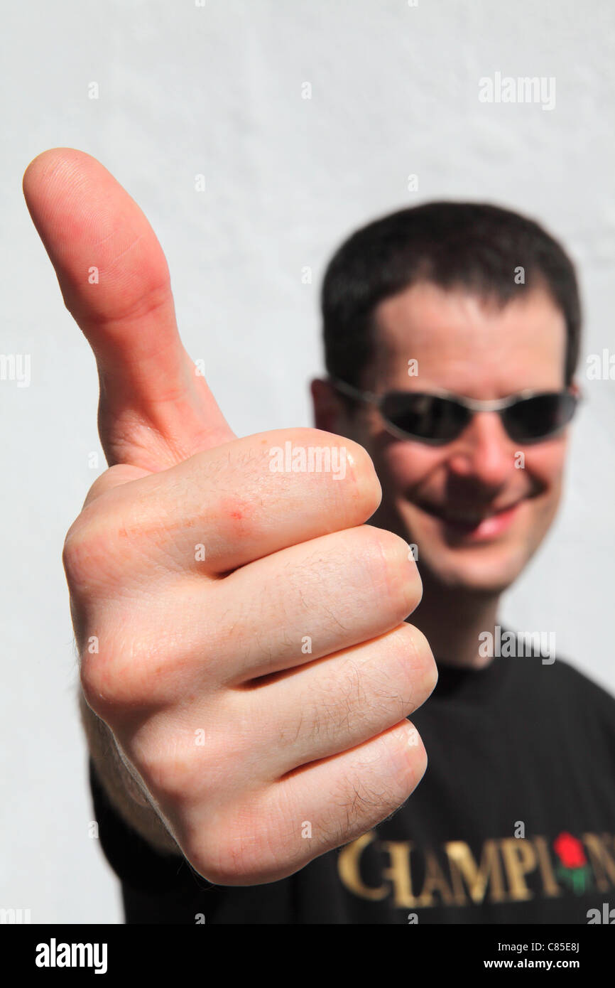 Un uomo dà un bel pollice fino gesto, segnalazione di approvazione. Foto Stock