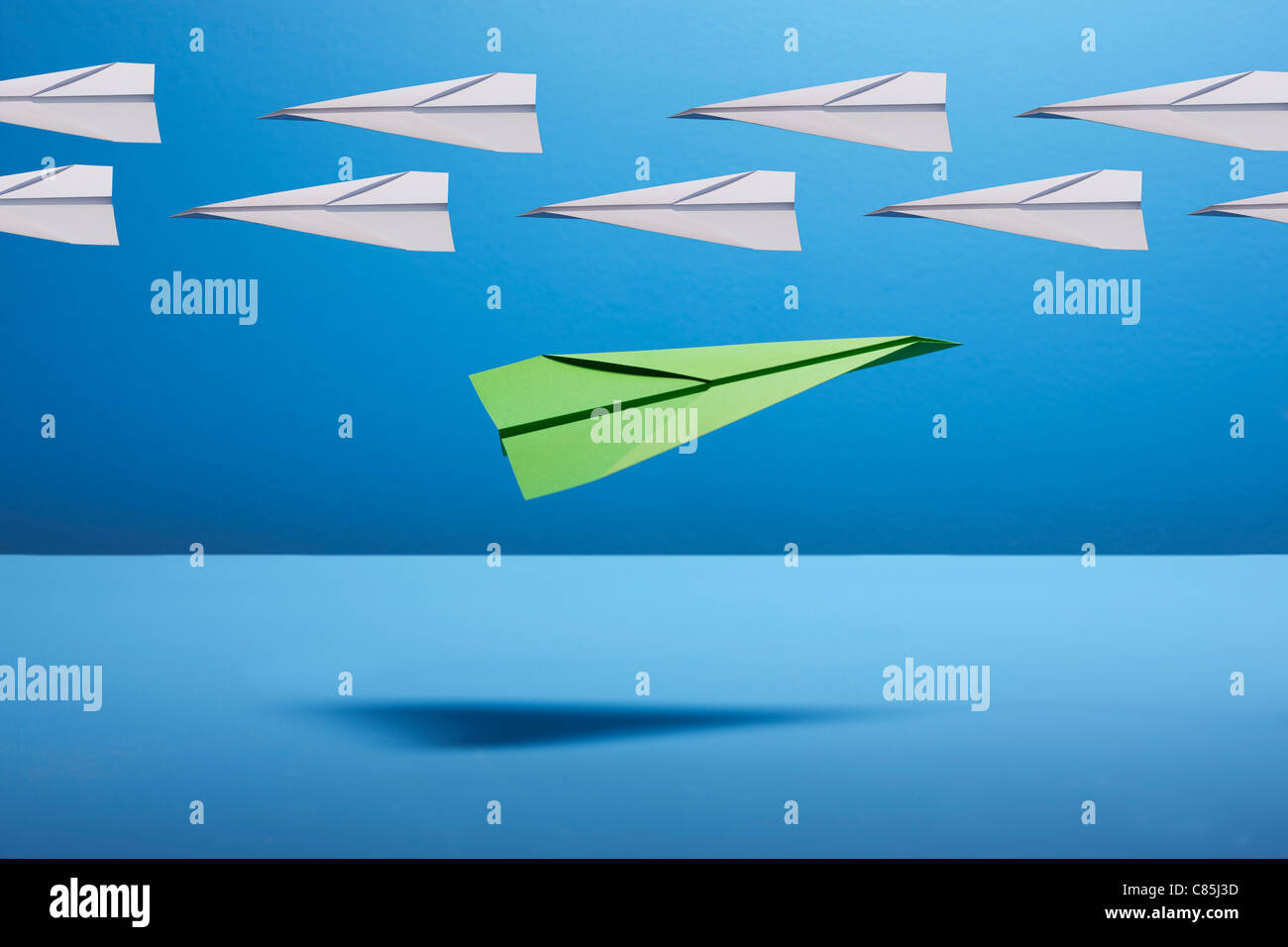 Gli aeroplani di carta contro sfondo blu Foto Stock