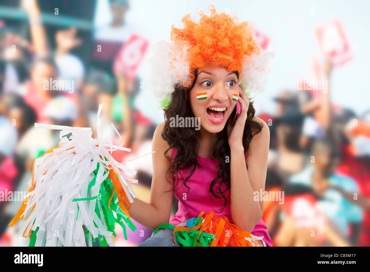 Ragazza a parlare su un telefono e il tifo Foto Stock