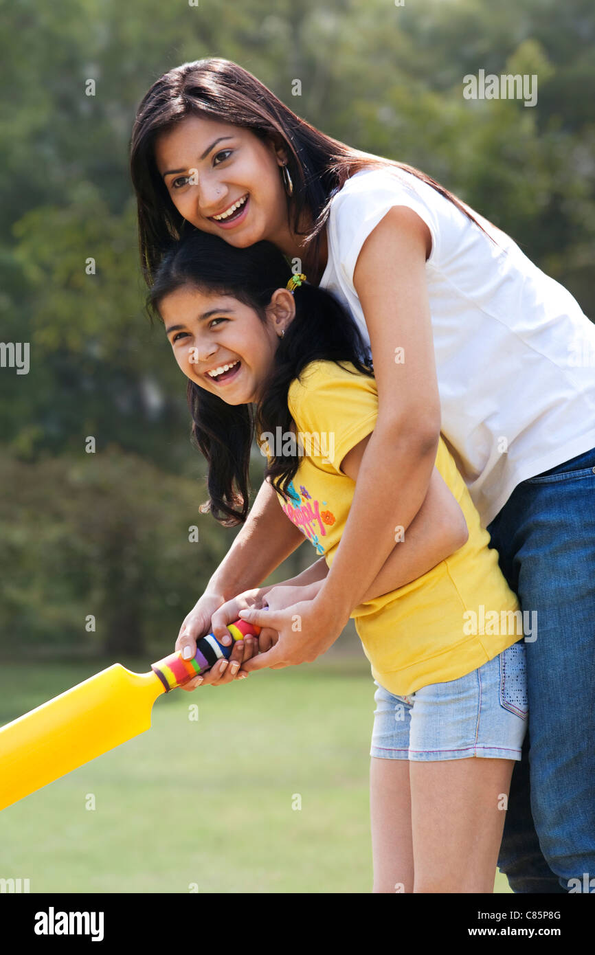 Madre e figlia a giocare a cricket Foto Stock