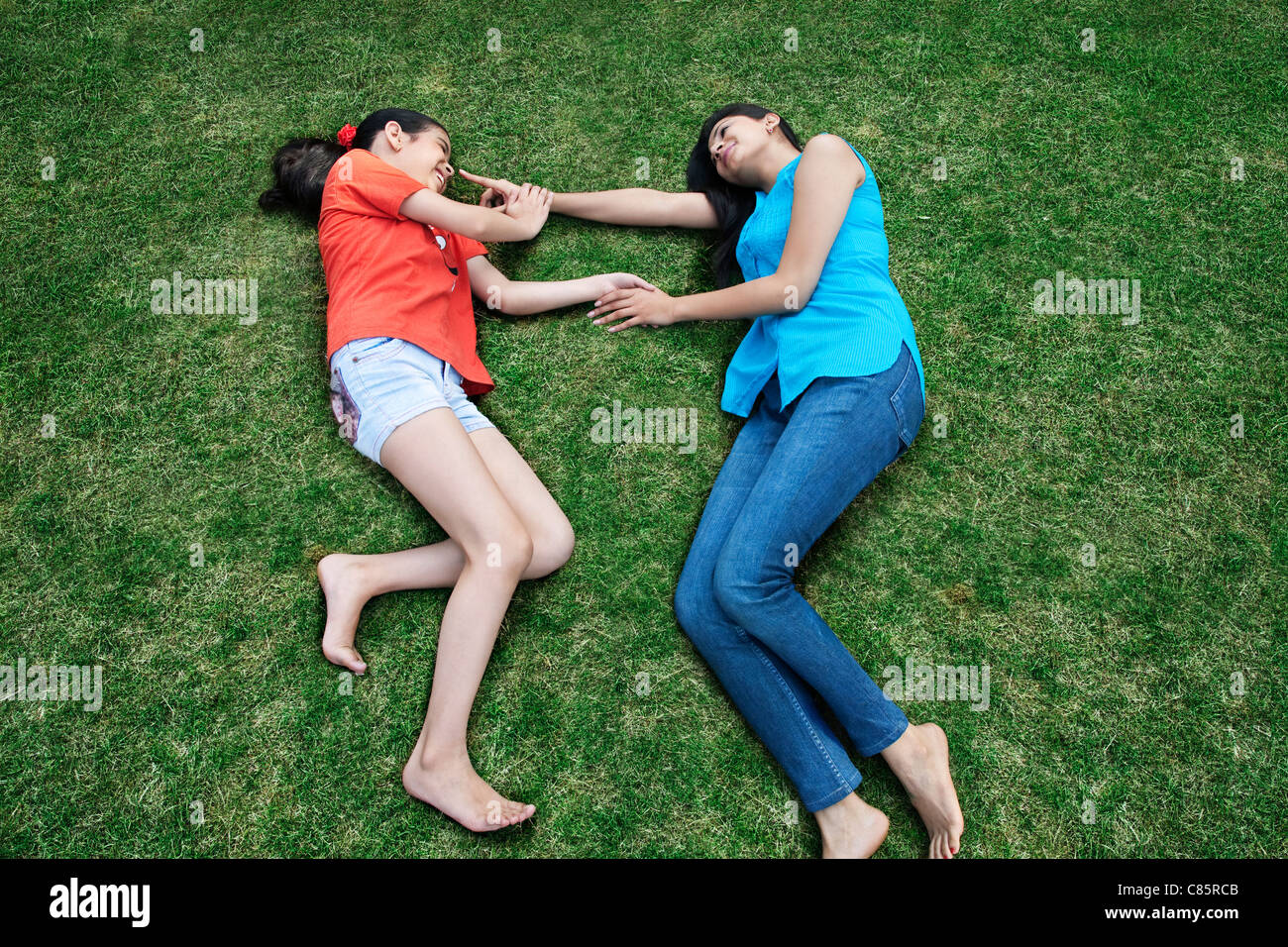 Madre e figlia sdraiati sull'erba Foto Stock