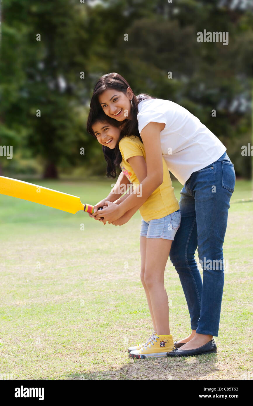 Madre e figlia a giocare a cricket Foto Stock