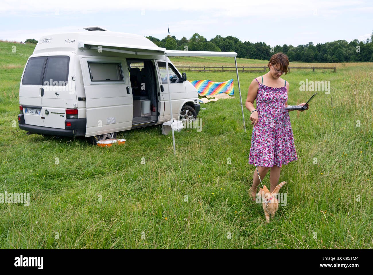 Polonia, Biebrza National Park, VW T4 Transporter camper, signora con un gatto al guinzaglio tramite GSM senza fili di connessione a internet Foto Stock