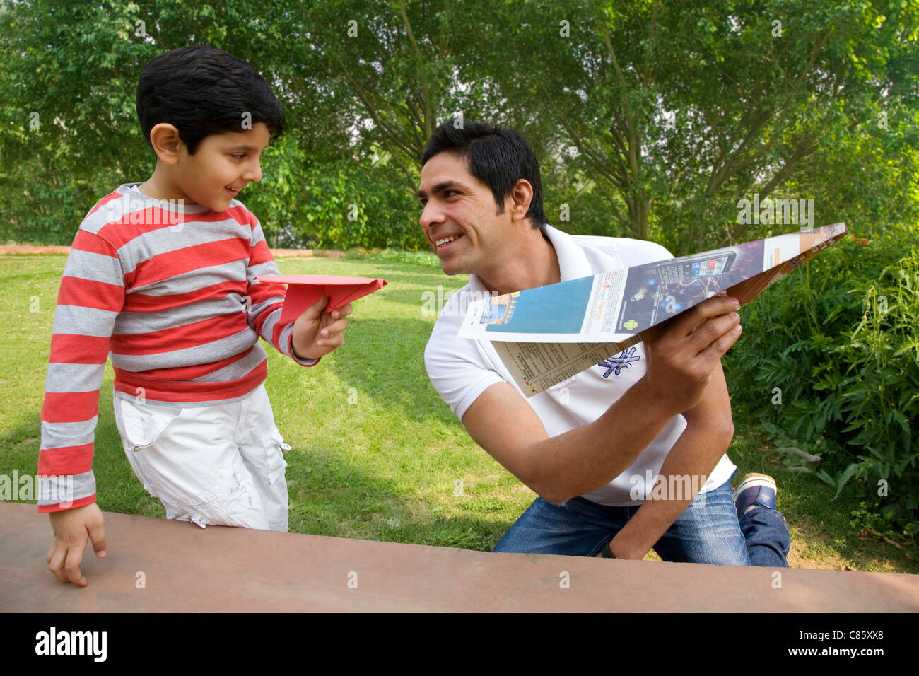 Padre e figlio si divertono con aeroplani di carta Foto Stock