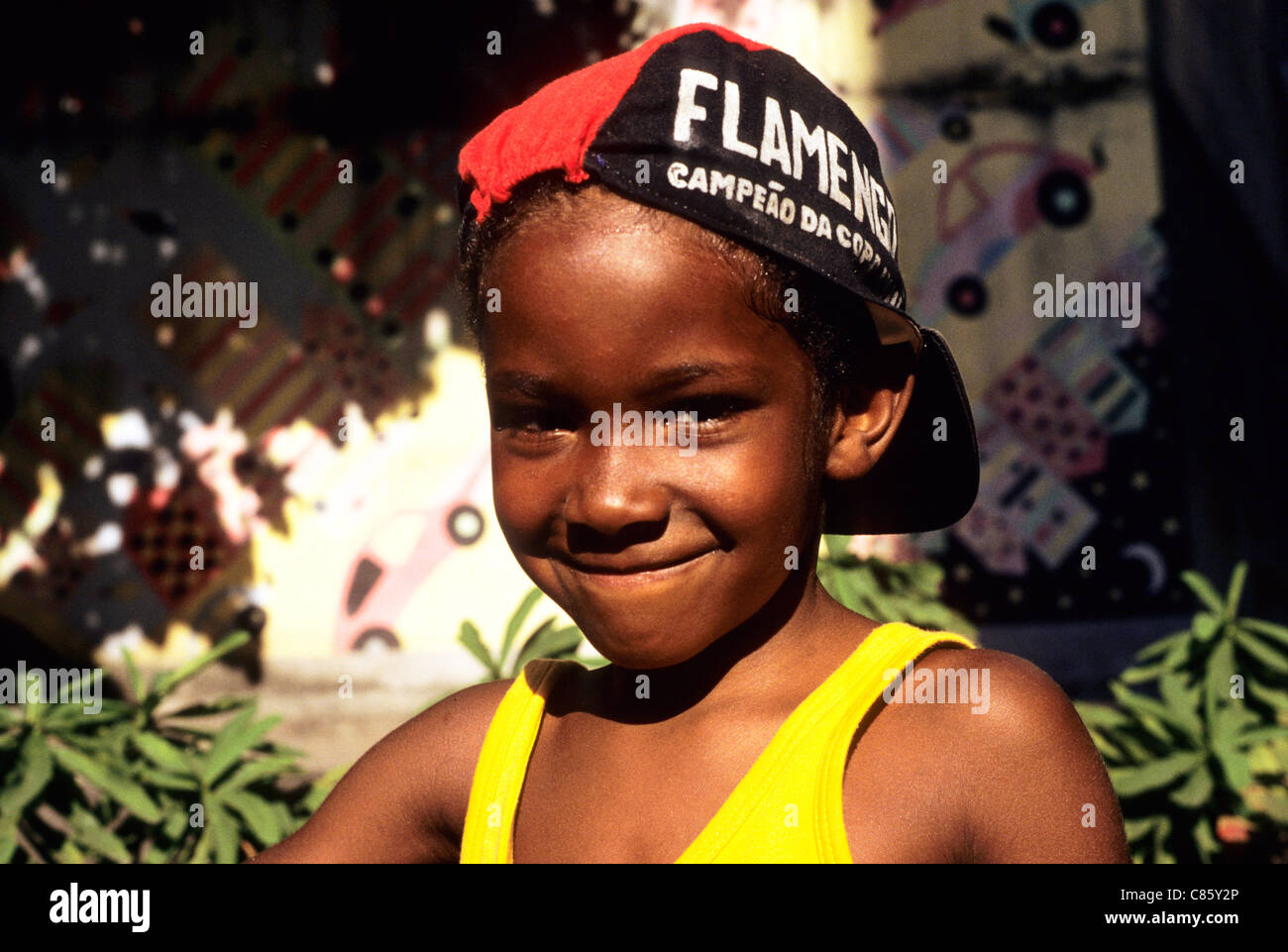 Rio de Janeiro, Brasile. Sorridente giovane ragazzo che indossa un Flamengo football team hat e giallo t-shirt senza maniche. Foto Stock