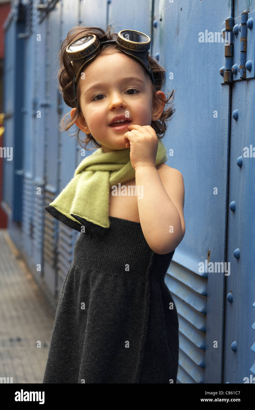 Immagine di moda di un bambino in un maglione e sciarpa che indossa gli occhiali di protezione. Foto Stock