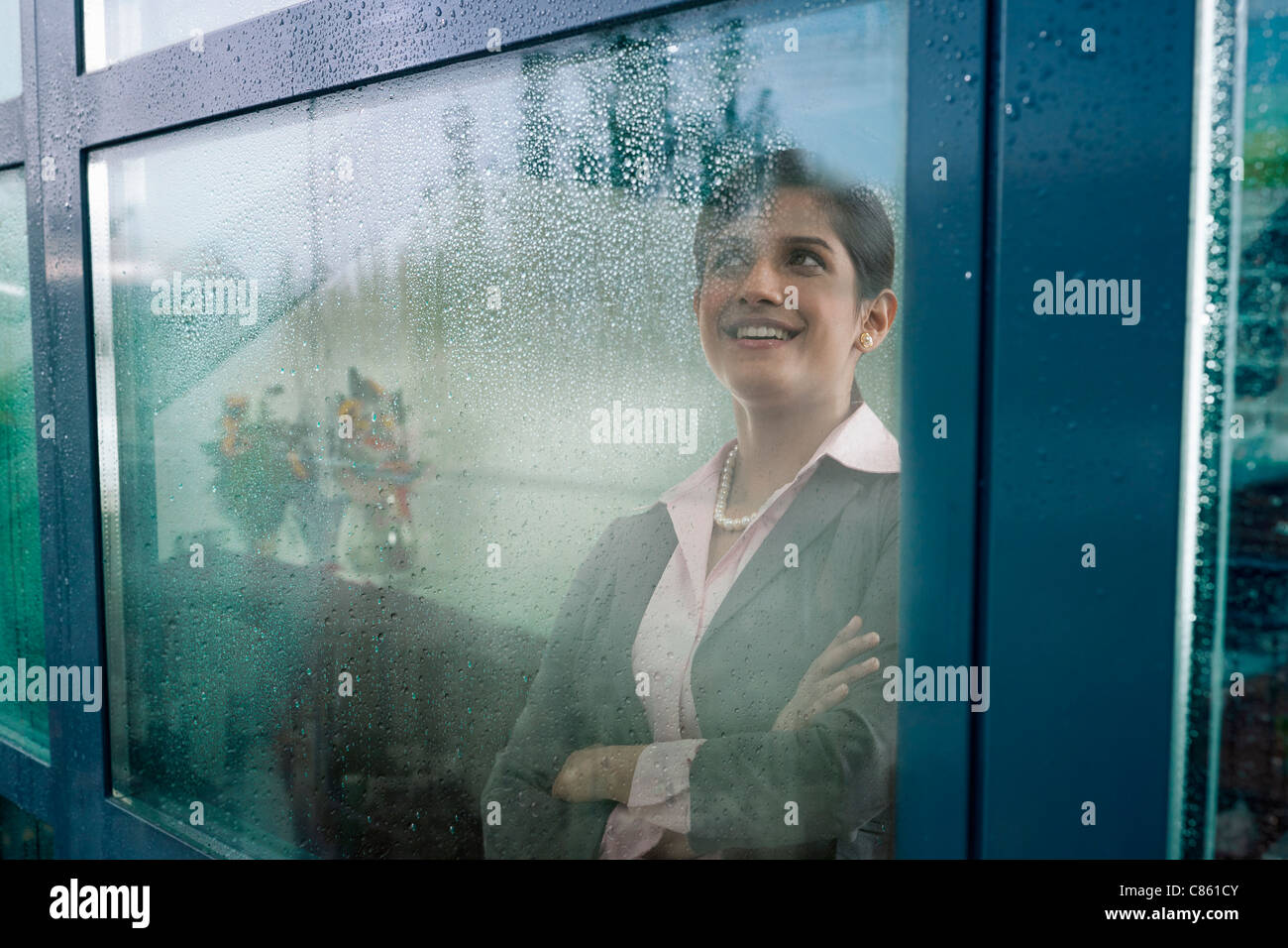 Imprenditrice guardando fuori della finestra Foto Stock