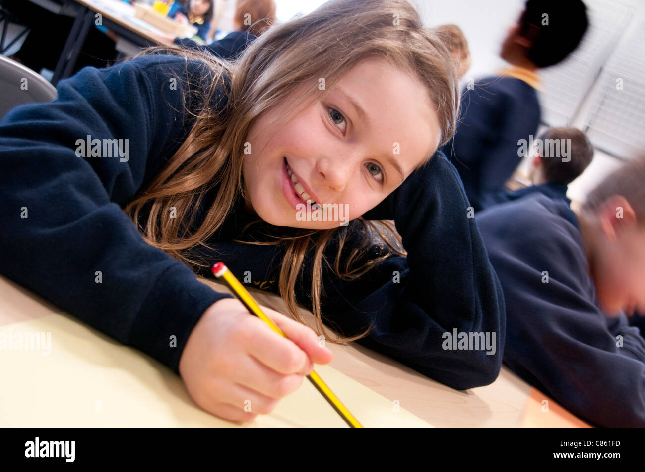 La scolaretta primario con matita in classe Foto Stock
