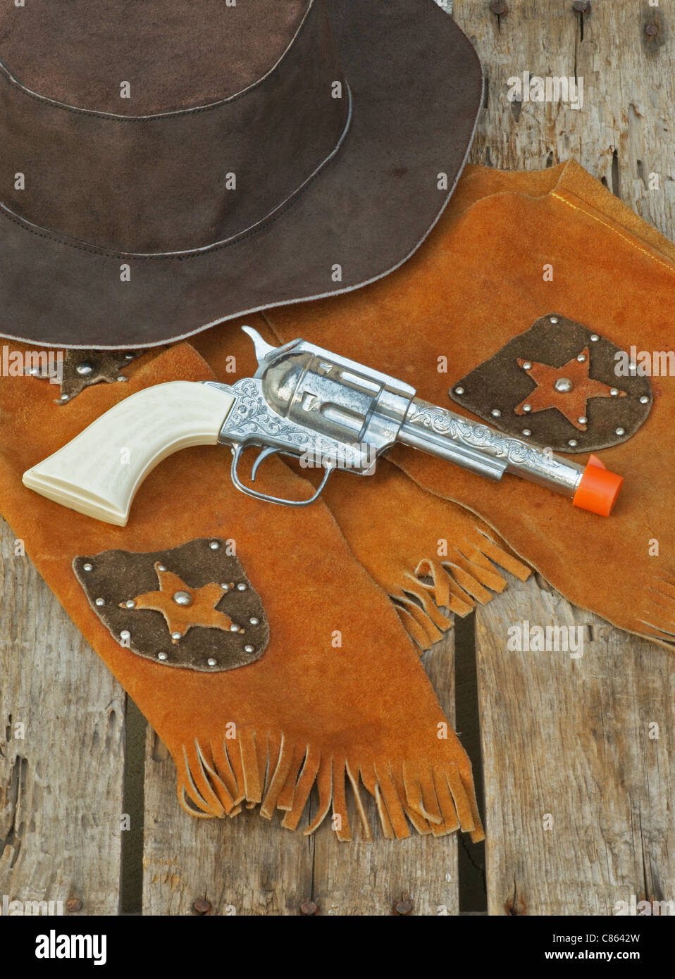 Pistola giocattolo, pelle giubbotto sheriff e western hat per un bambino Foto Stock