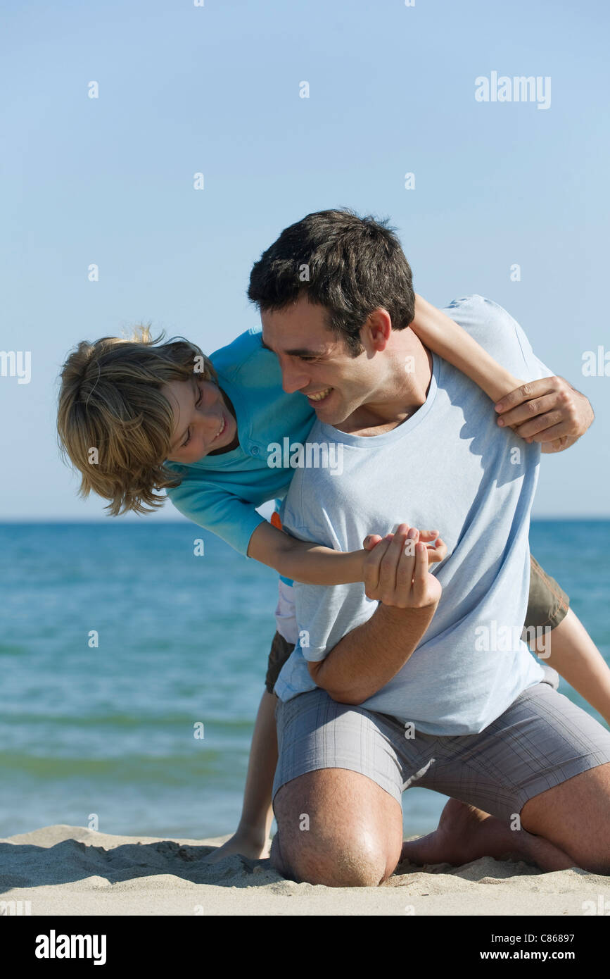 Padre e figlio avente insieme divertimento in spiaggia Foto Stock