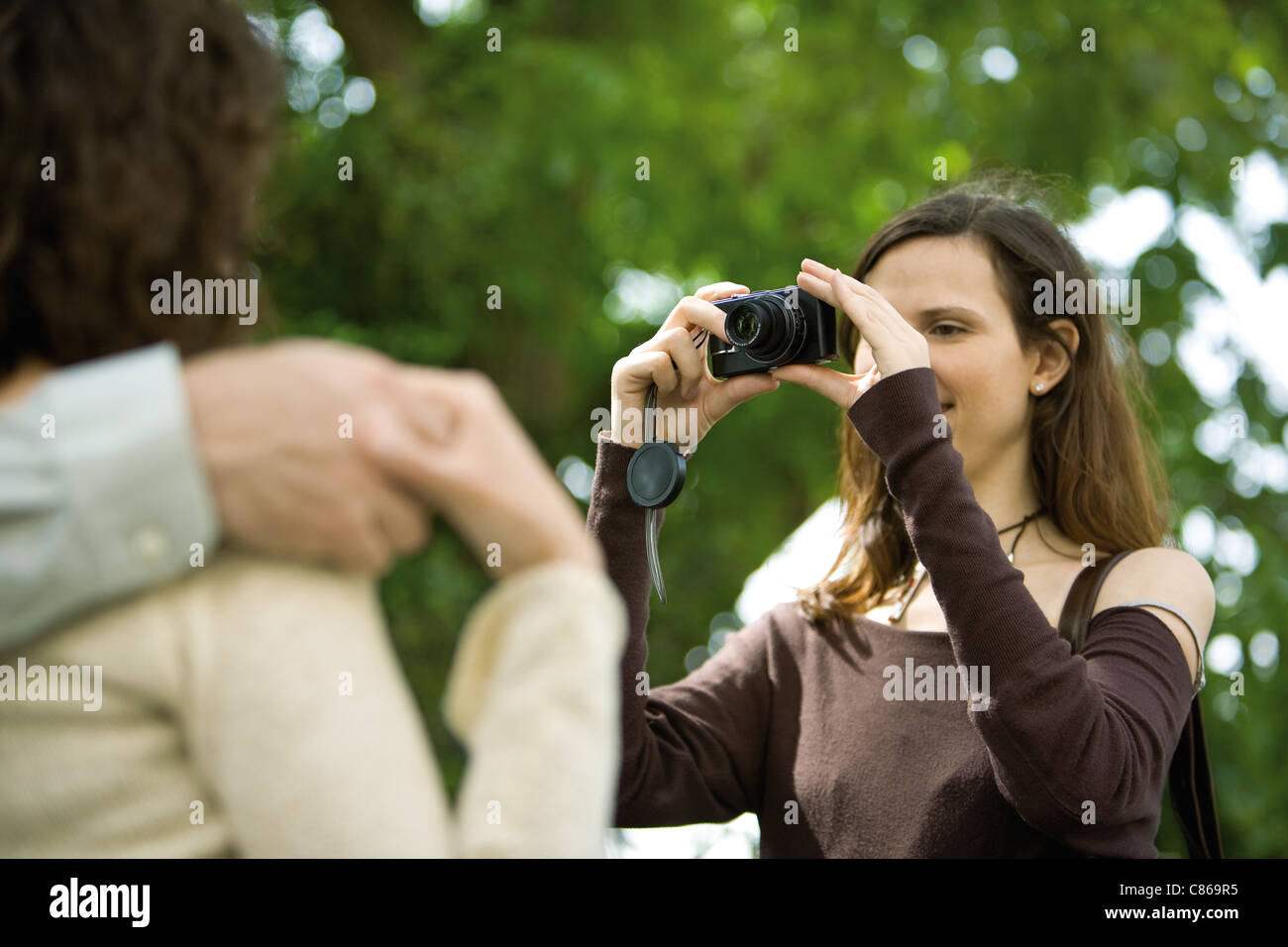 Fotografare la donna giovane con fotocamera digitale, al di sopra della spalla Foto Stock