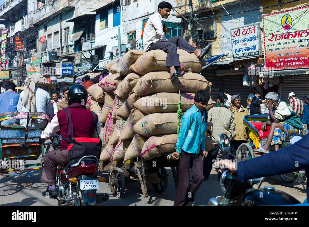 Facchini con sacchi di date a Khari Baoli spezie e cibi essiccati mercato, Vecchia Delhi, India Foto Stock