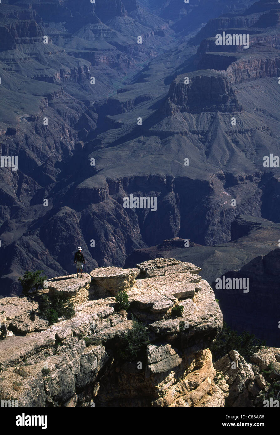 Uomo in piedi sul bordo del Grand Canyon, Arizona Foto Stock