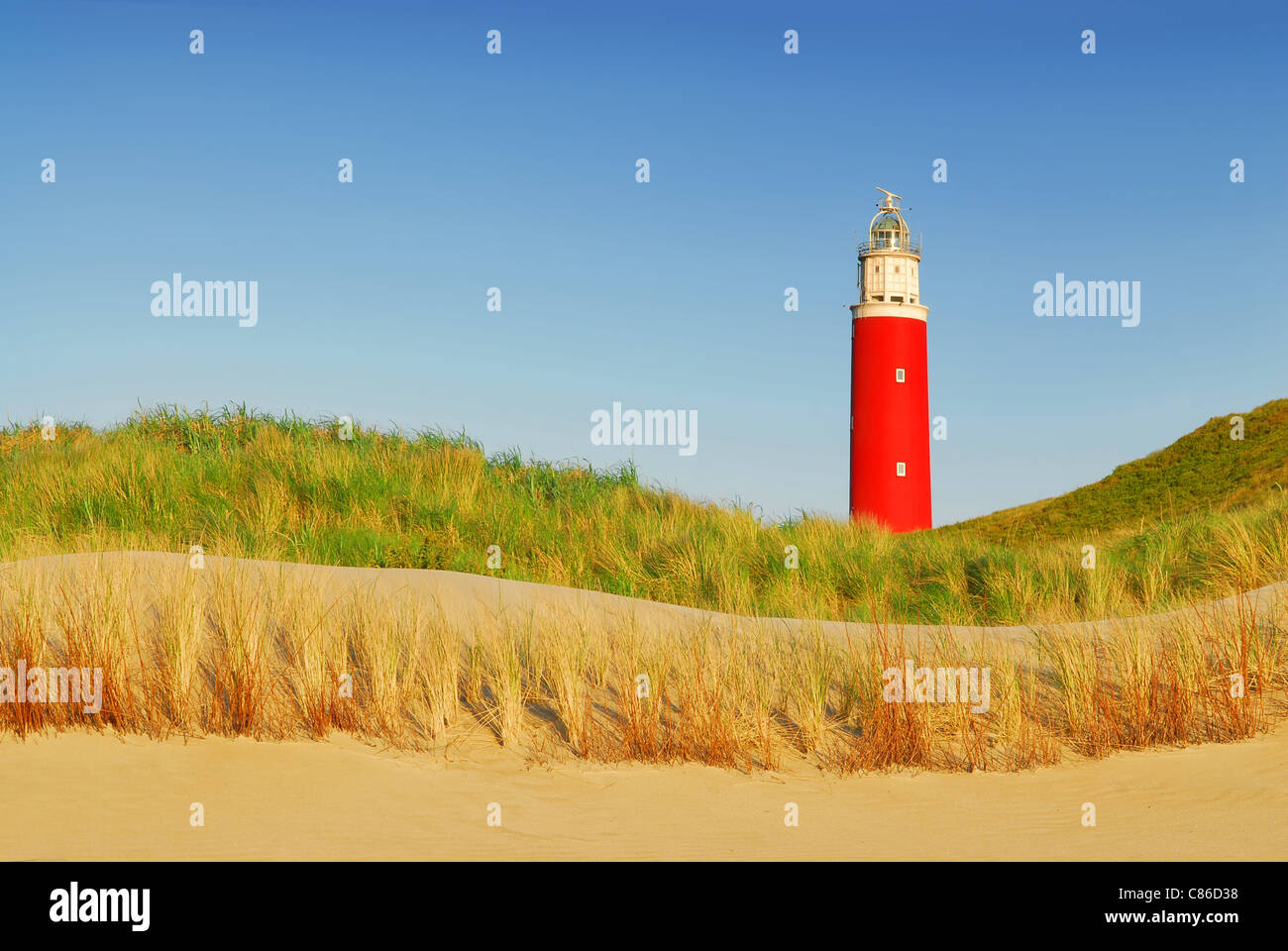 Faro con dune, spiaggia e cielo blu sull isola olandese di Texel Foto Stock