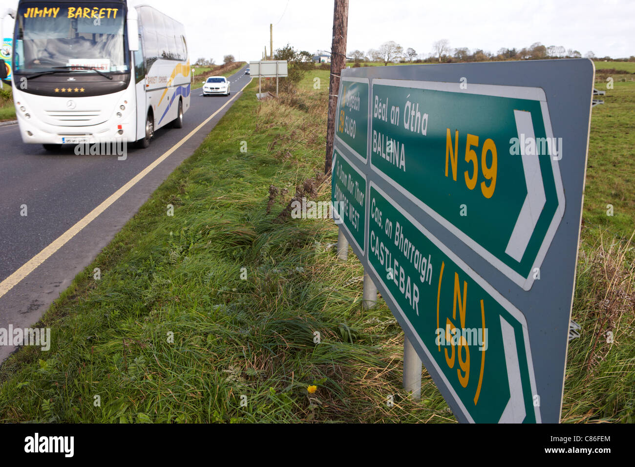 Pullman turistico oltrepassando cartello stradale segnaletica per n59 strada nazionale ovest a ballina castlebar County Mayo Repubblica di Irlanda Foto Stock