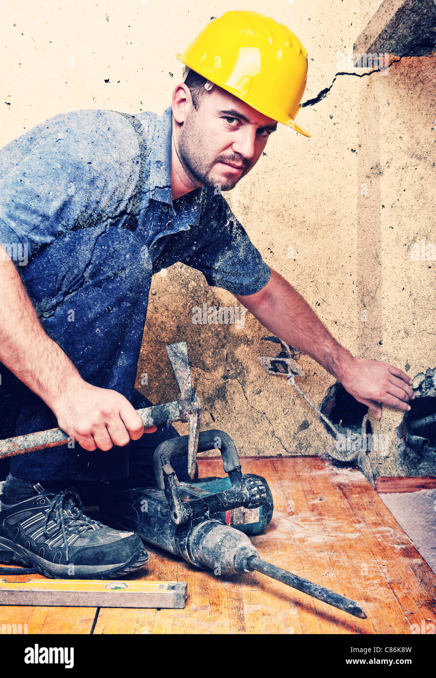 Lavoratore manuale con martello in cantiere, indoor shot Foto Stock