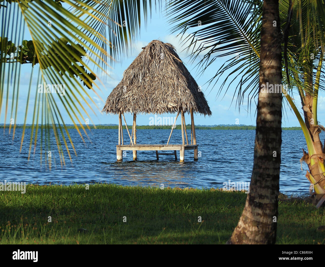 Rifugio tropicale su acqua con Palm con il tetto di paglia del tetto, sul mare dei Caraibi, America centrale e di Panama Foto Stock