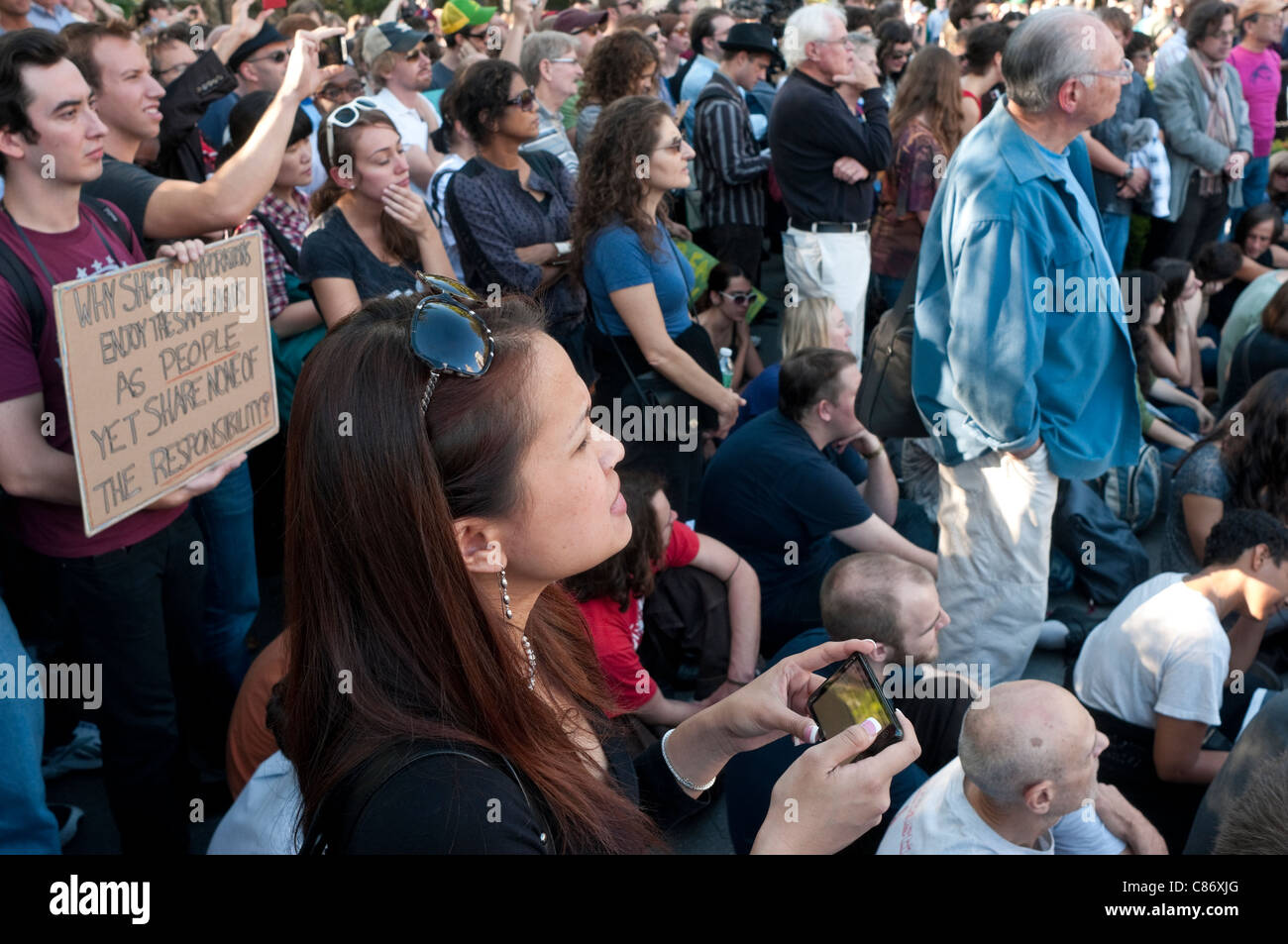 Donna di messaggistica di testo durante occupare Wall Street Assemblea Generale Foto Stock