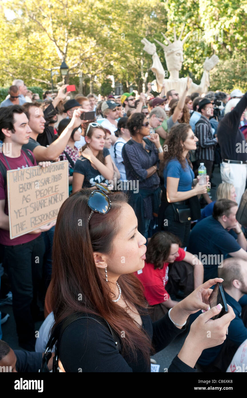 Donna di messaggistica di testo durante occupare Wall Street Assemblea Generale Foto Stock