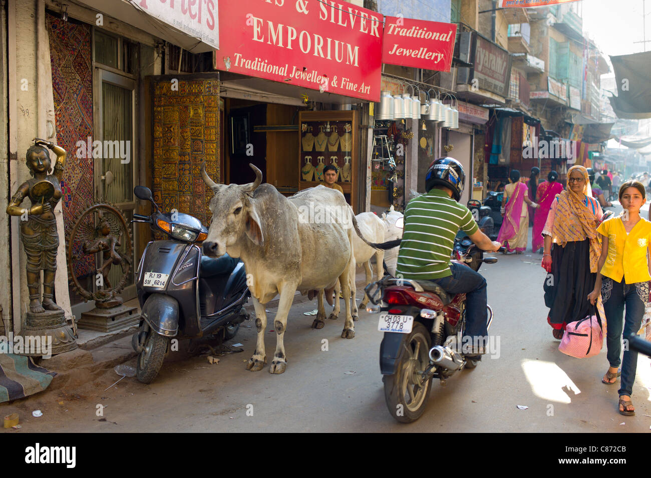 La strada affollata scena persone, vacche, il traffico a Sardar Mercato a Girdikot, Jodhpur, Rajasthan, India settentrionale Foto Stock