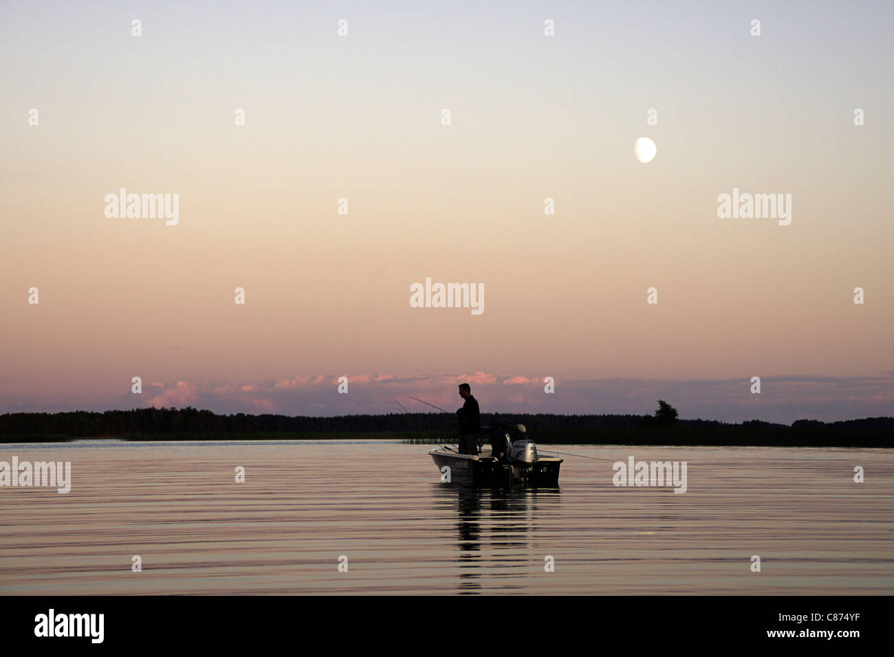 Sera su un lago svedese con una barca con i pescatori, Hedesunda, Svezia Foto Stock