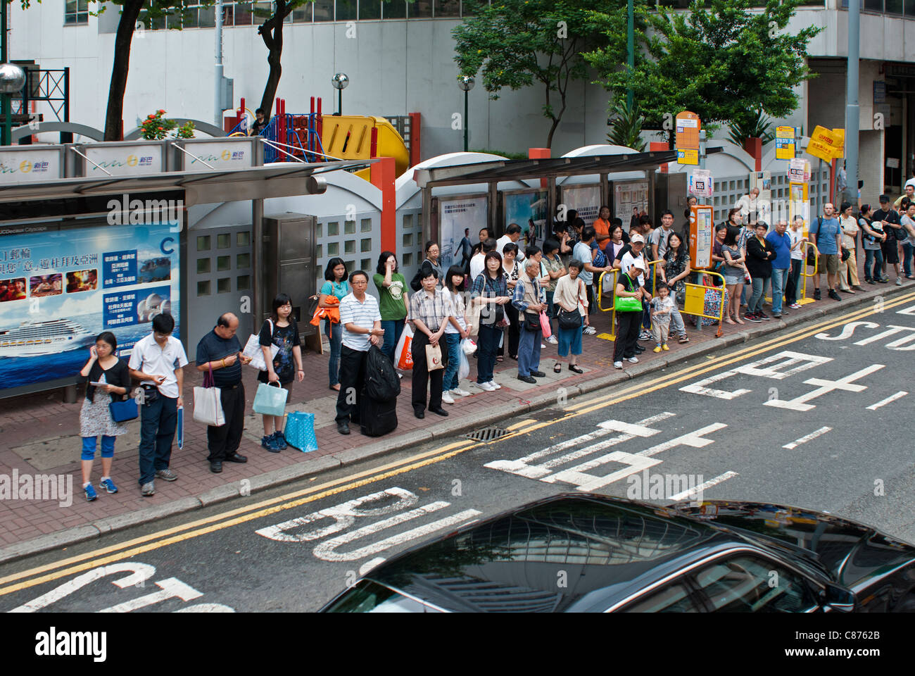 Persone in attesa alle fermate degli autobus, Wan Chai, Hong Kong Foto Stock